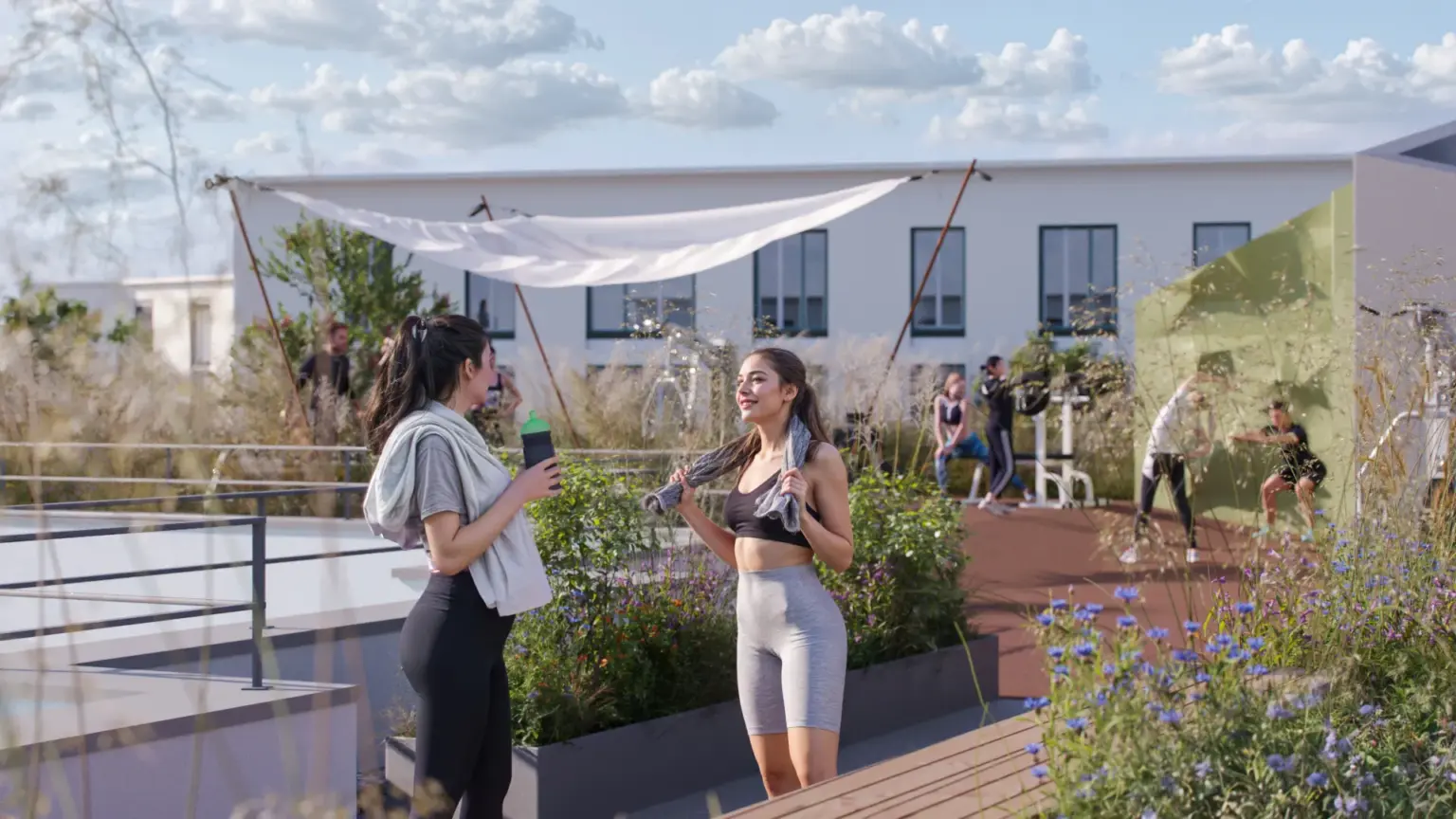 Menschen trainieren im Sportbereich auf der Dachterrasse der Wohnanlage ORPLID