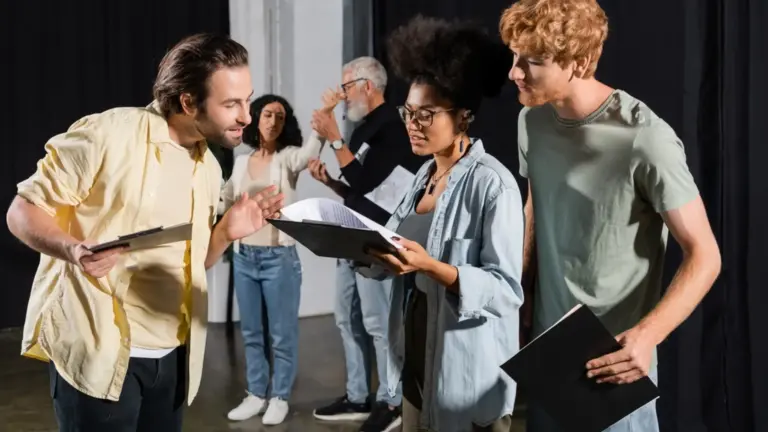 Gruppe junger Erwachsener probt gemeinsam mit Drehbüchern in der Hand